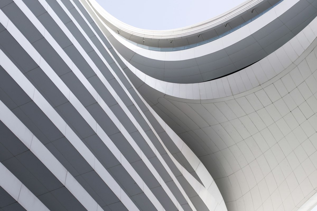 Façade courbe d'un immeuble contemporain vue en contre-plongée : des lignes qui convergent